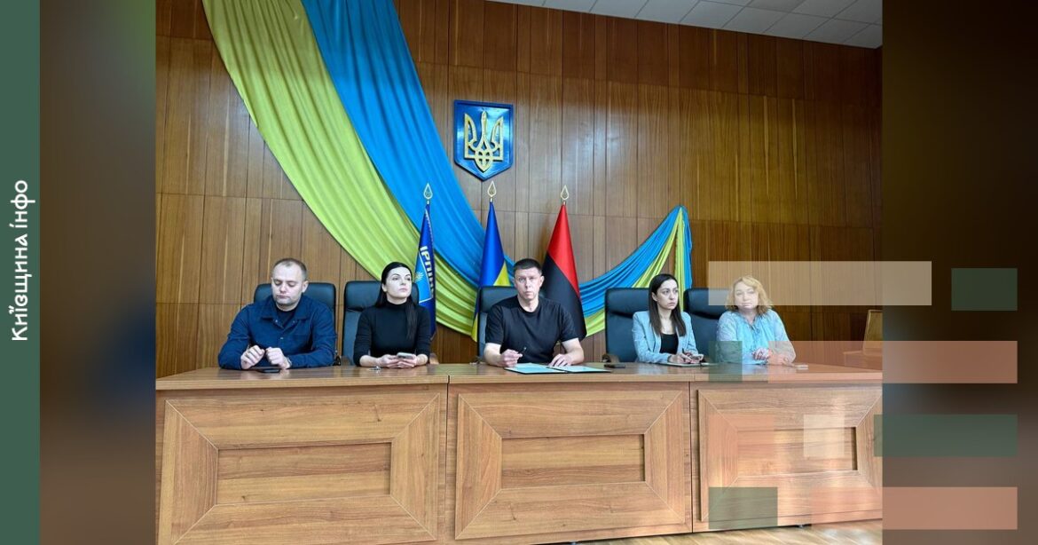 Нарада керівників комунальних підприємств Ірпінської громади за столом з українськими прапорами