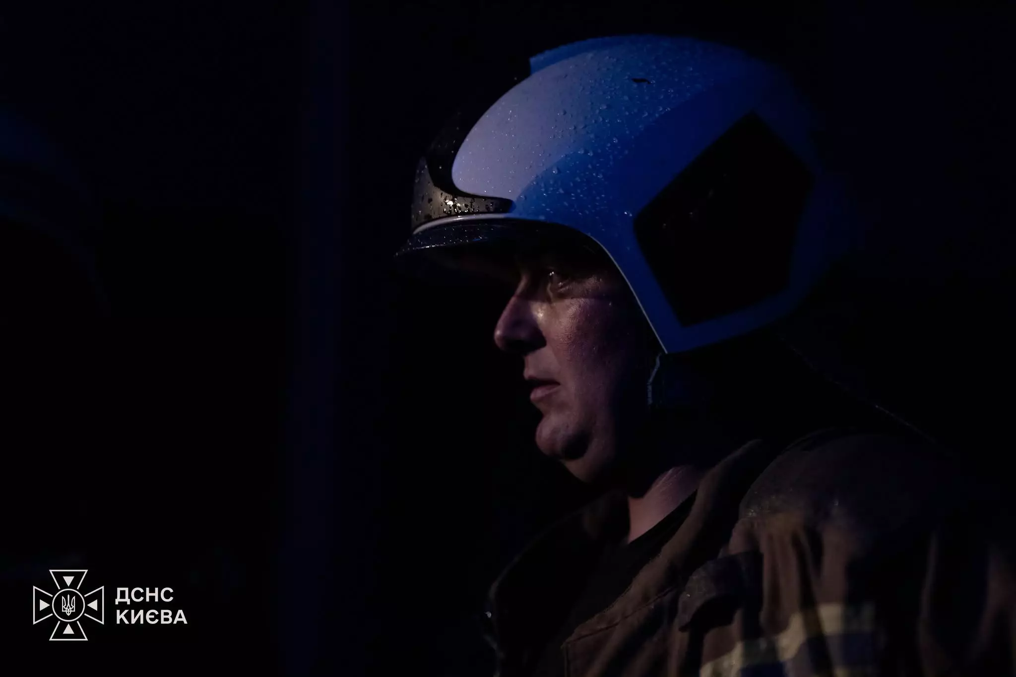 Рятувальник у синьому касці в темряві під час ліквідації наслідків атаки