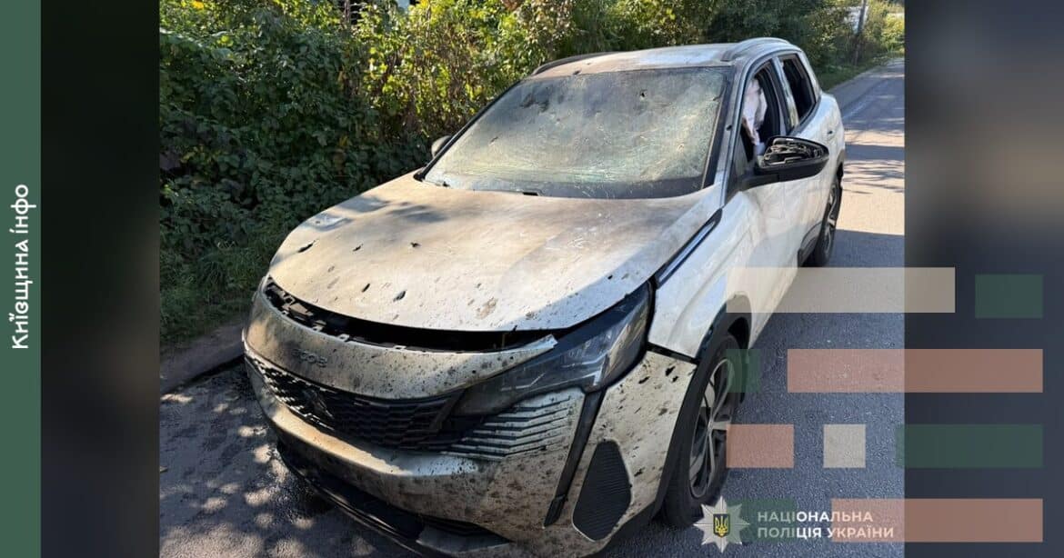 Пошкоджений білий автомобіль з численними отворами від уламків після ворожої атаки в Бучанському районі Київської області