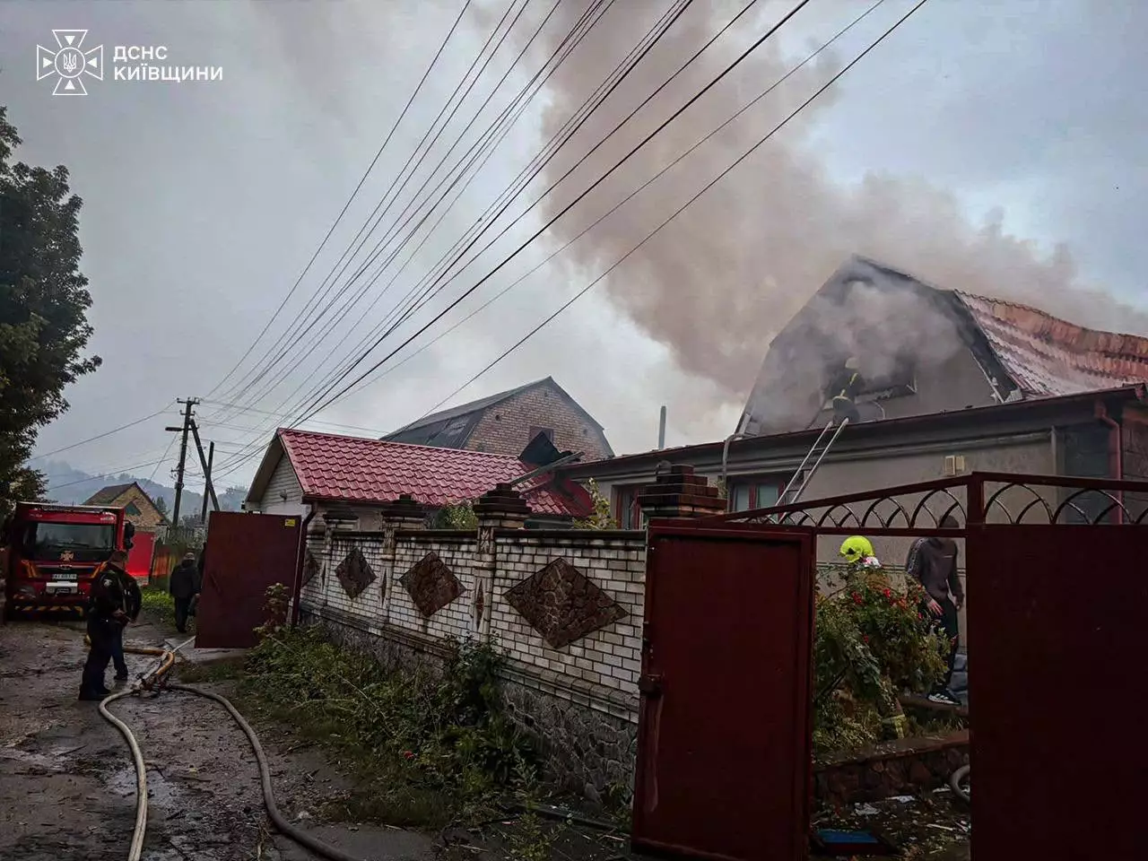 Рятувальники гасять пожежу у житловому будинку з видимим дымом