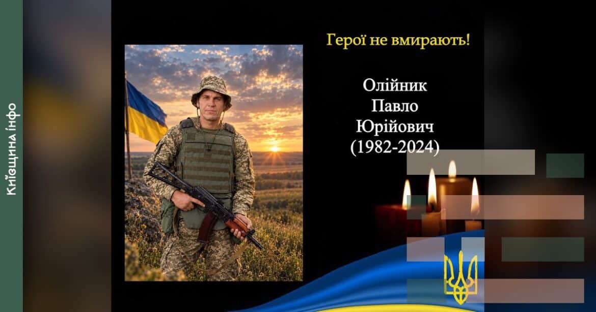 Військовослужбовець у камуфляжі з гвинтівкою поряд із українським прапором на тлі заходу сонця, меморіальна композиція з