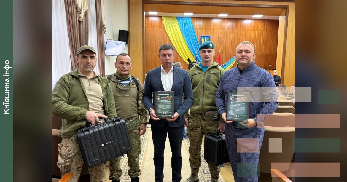 Військові та цивільні особи тримають нагороди та квадрокоптери на сесії Ірпінської міської ради