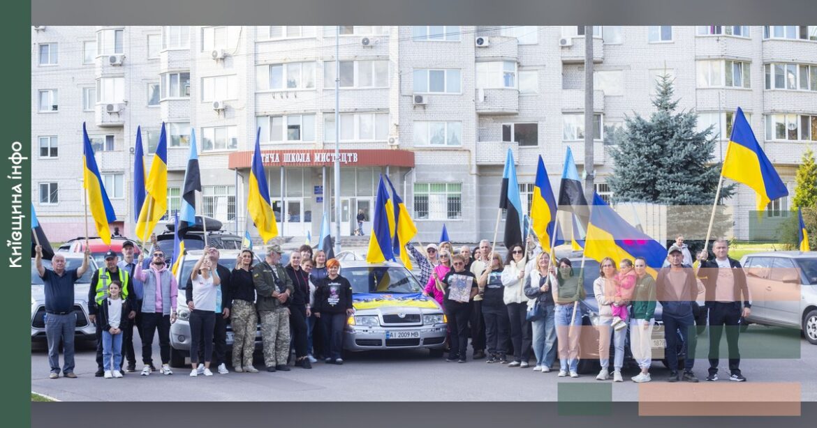 Люди з українськими прапорами стоять на площі міста Глеваха під час акції на підтримку родин зниклих безвісти захисників