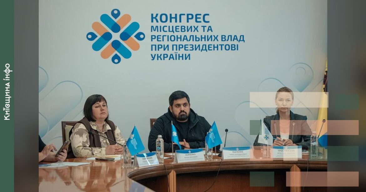 Три посадовці сидять за столом на засіданні Конгресу місцевих та регіональних влад при Президентові України, позаду видна