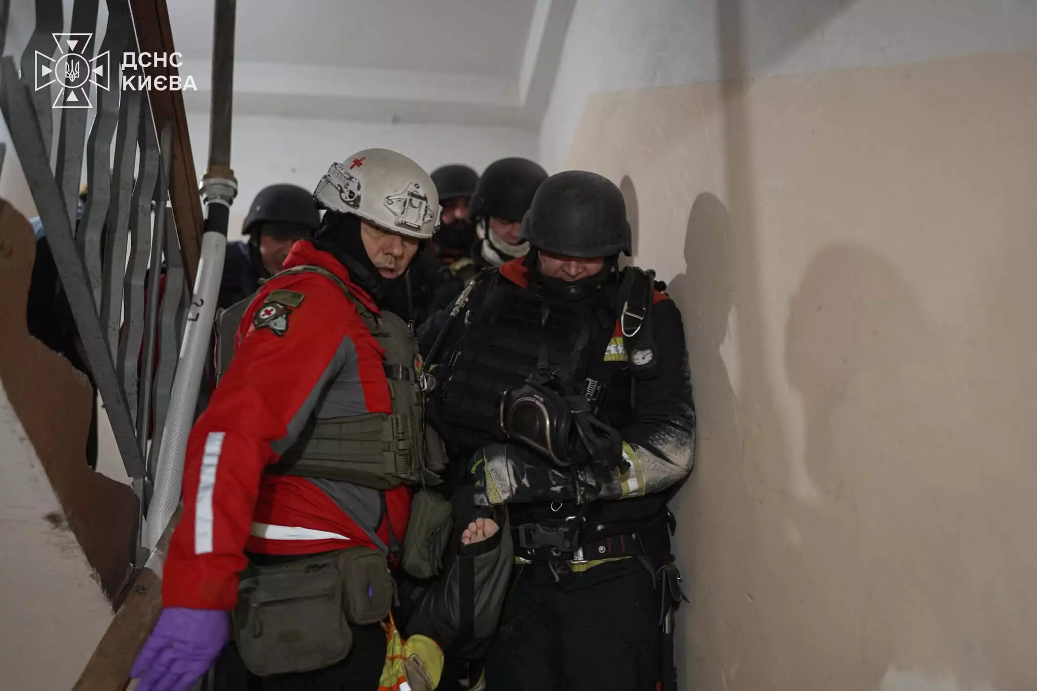Команда рятувальників і поліцейських евакуює людину по сходах зі спаленого будинку