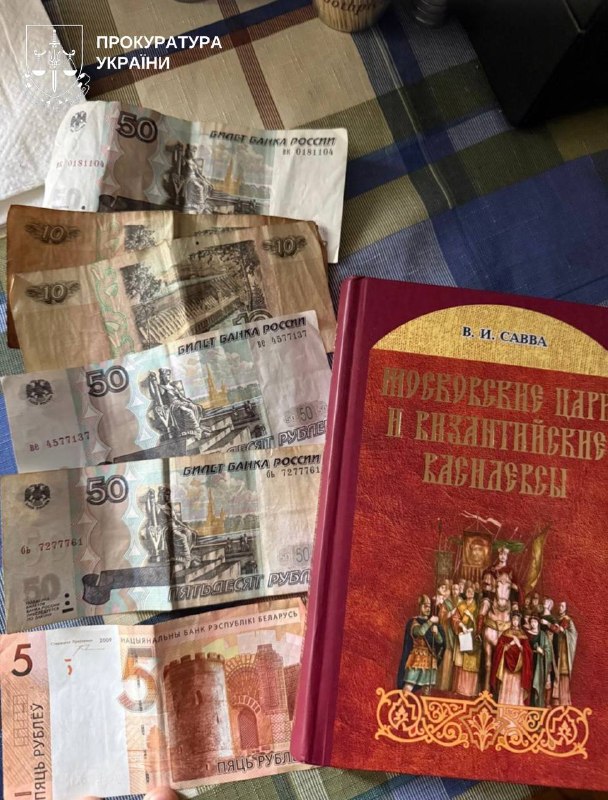 Російські рублі номіналом 50 та 5 і червона релігійна книга на квадратній тканини з клітинастим узором