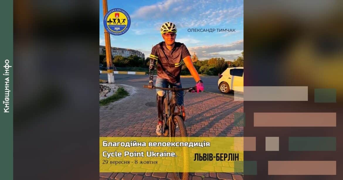 Учасник велозаїзду Львів-Берлін на велосипеді в оранжевій футболці та шоломі на міській набережній