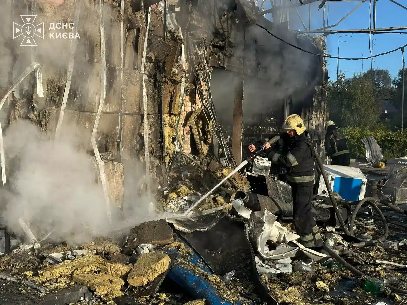 Рятувальники ліквідують вогонь біля обгорілої стіни будівлі на місці атаки