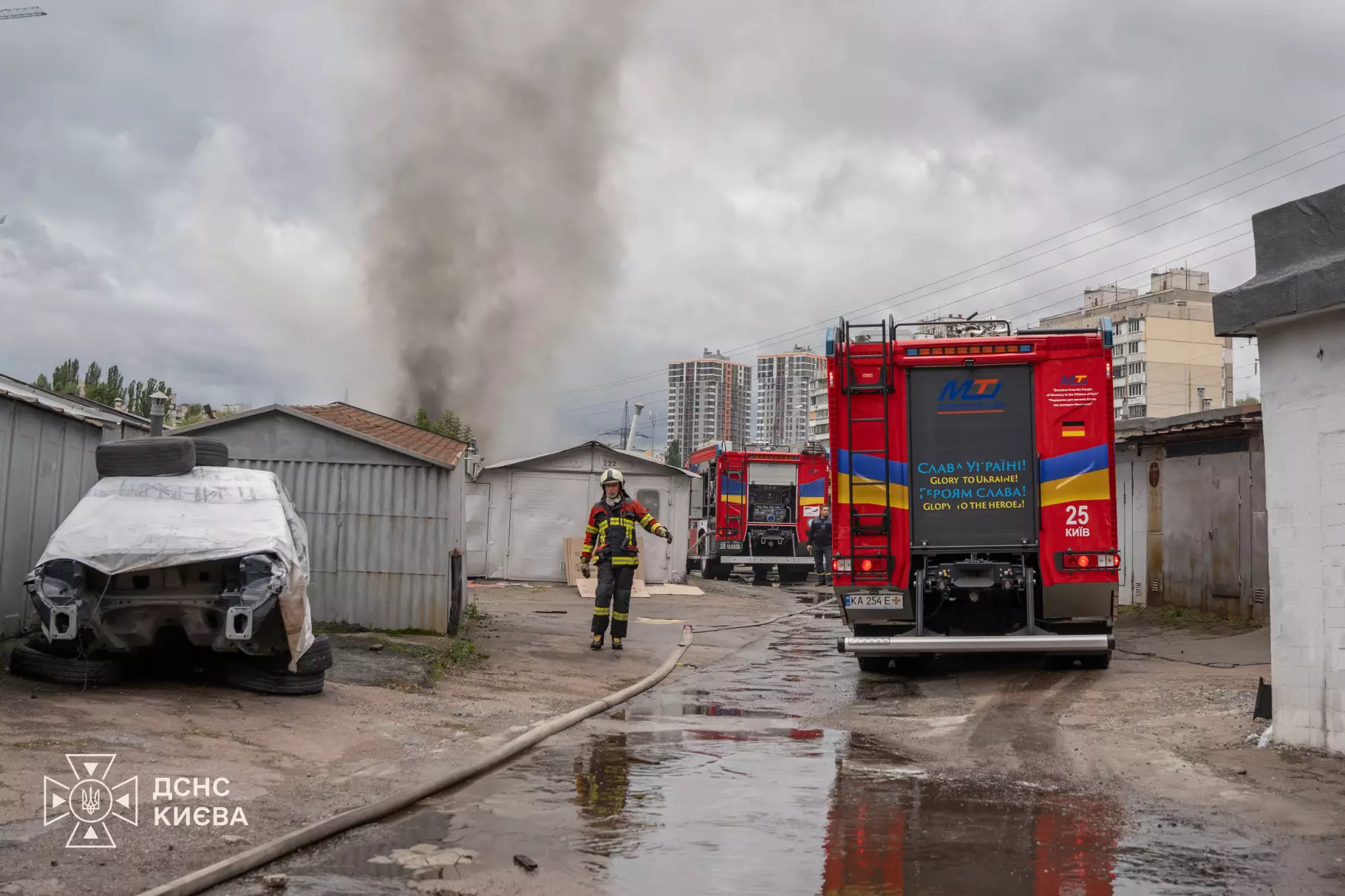 Пожежна машина і рятувальники гасять пожежу в гаражних боксах Оболонського району
