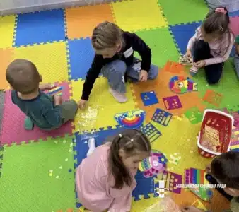 Діти грають з іграшками на кольоровому килимку під час творчого заходу для дітей
