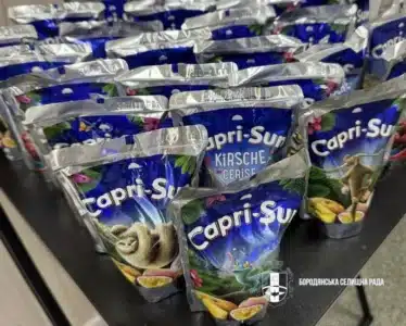 Кілька упакованих бутилок напою Capri-Sun лежать на столі для розповсюдження