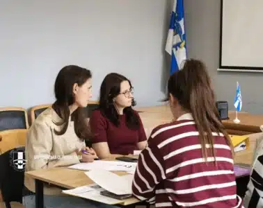 Три жінки обговорюють документи під час міжвідомчого заходу з навчання за проєктом «Догляд вдома