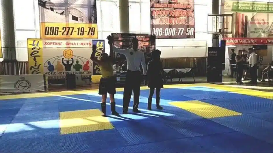 Три учасники на сцені з матами під час награждення чемпіонату України з хортингу у Первомайську