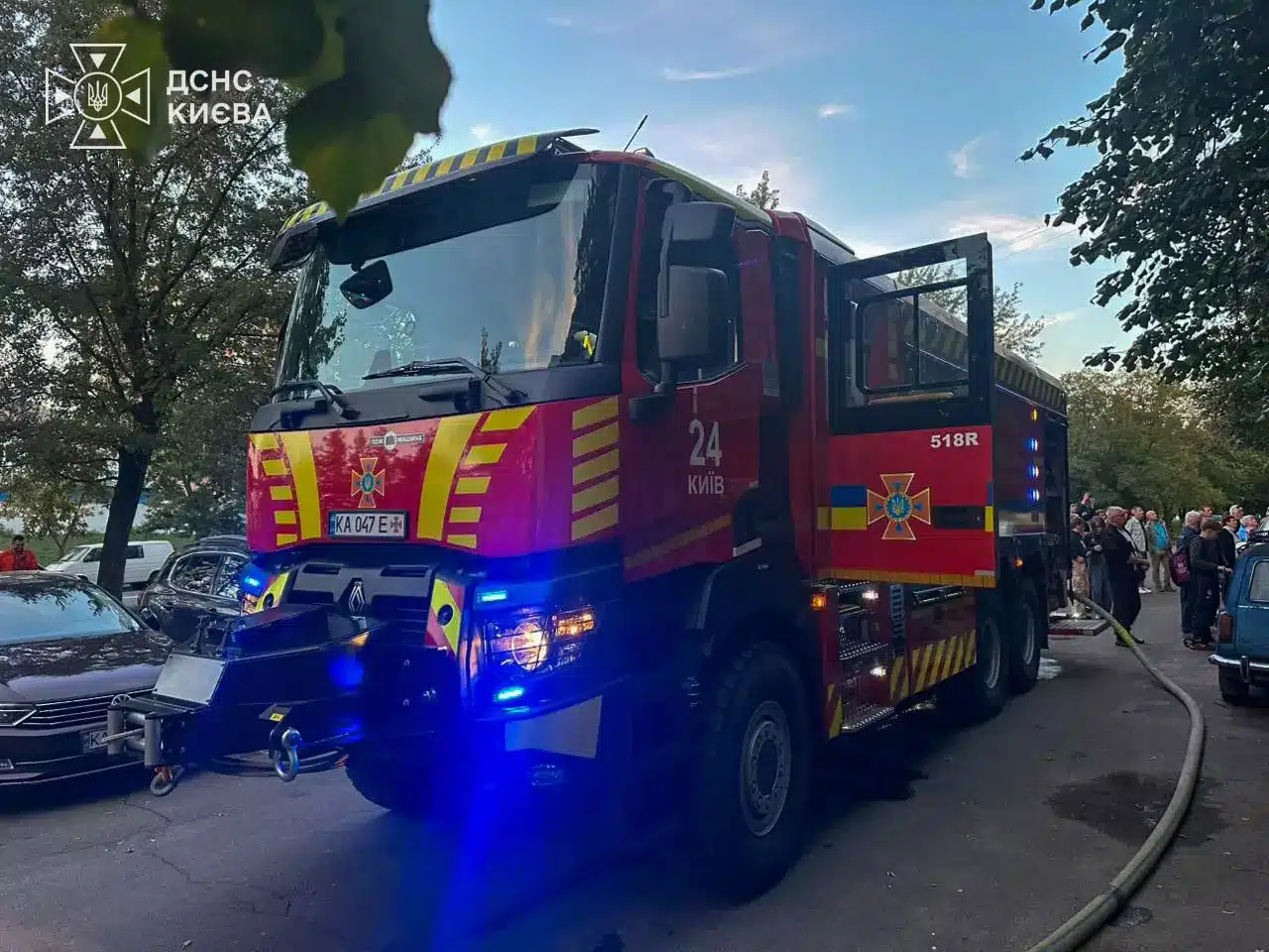 Пожежна машина ДСНС Києва з увімкненими маячами припаркована біля входу до житлового будинку