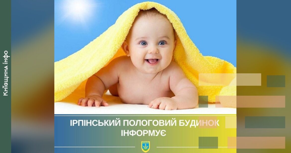 Усміхнене немовля під жовтою рушником на блакитному тлі до статті про народження 36 дітей в Ірпінському пологовому будинку