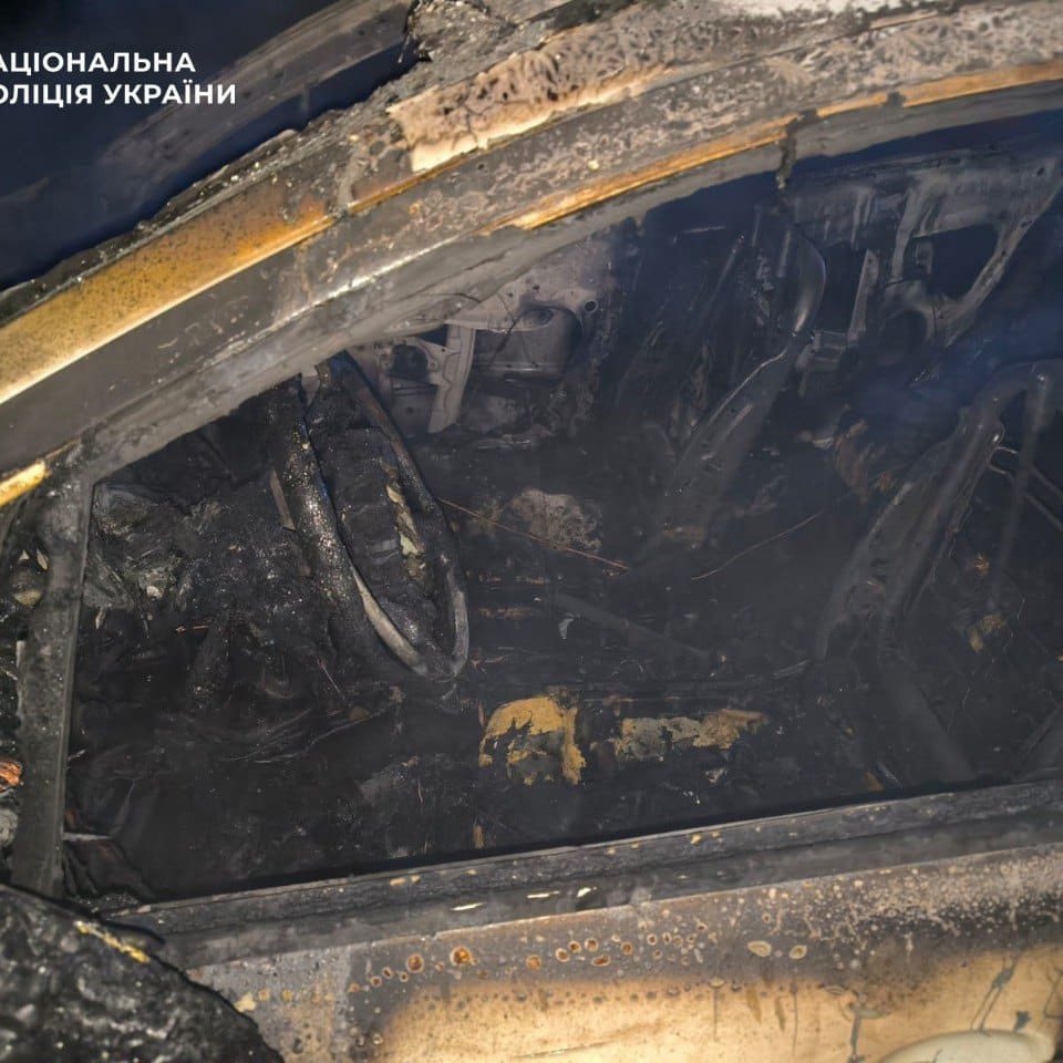 Обвуглений салон автомобіля крізь раму вікна з вигорілими сидіннями та залишками панелі приладів, знімок від Національної