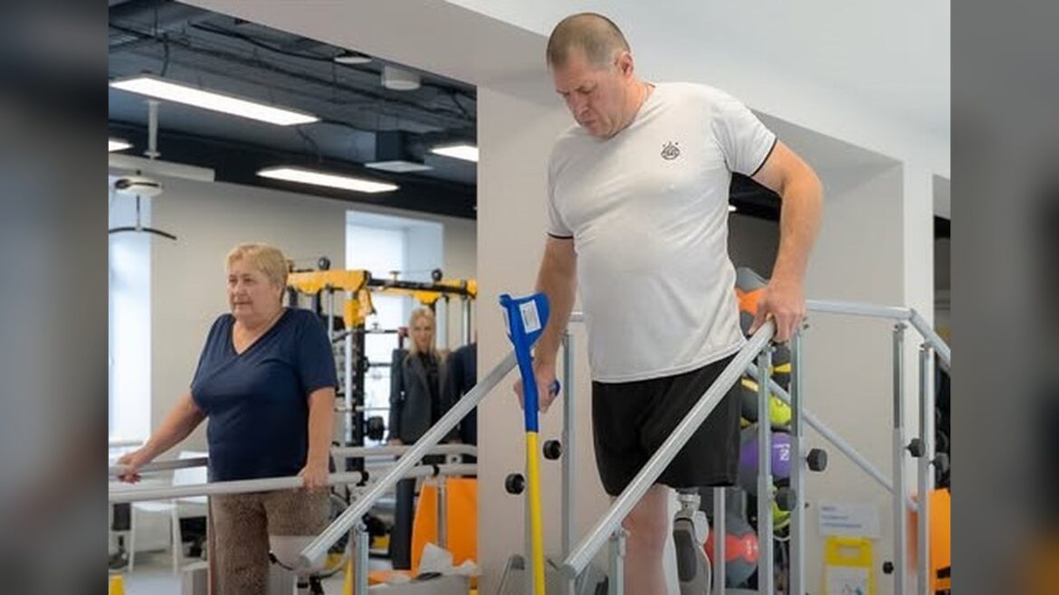 Чоловік та жінка виконують реабілітаційні вправи на тренажерах у сучасному реабілітаційному центрі
