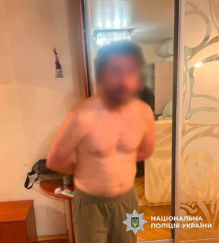 Чоловік у оранжевій сорочці під час затримання поліцією за стрілянину з балкона по автомобілю