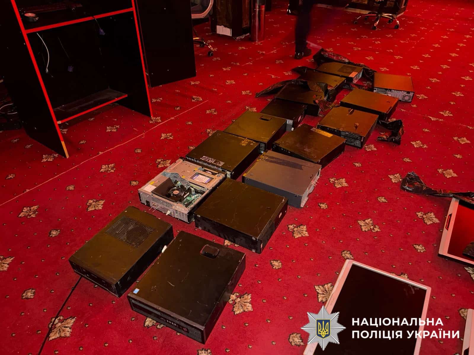 Вилучені системні блоки та монітори, розкладені рядами на червоному килимі в гральному залі
