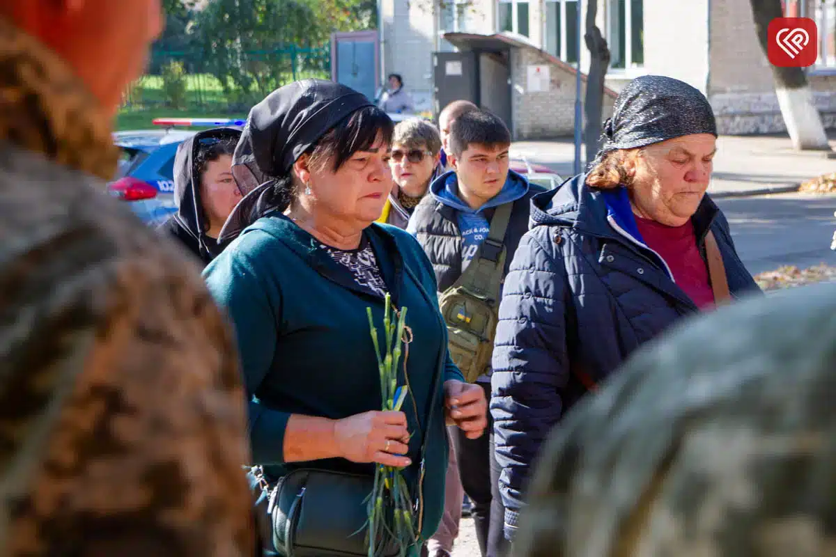 Місцеві жителі і військові беруть участь у траурній церемонії на вулиці міста