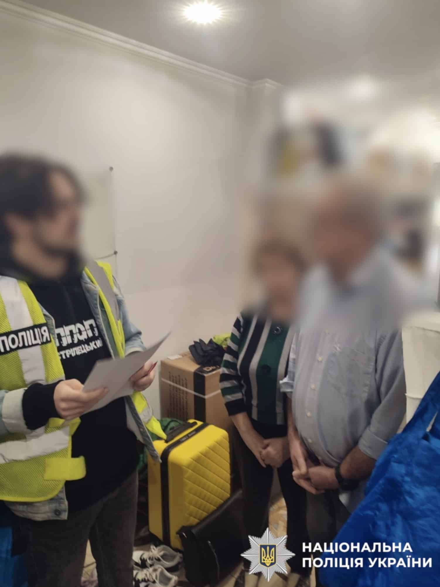 Поліцейський проводить опитування осіб під час розслідування схеми виведення коштів