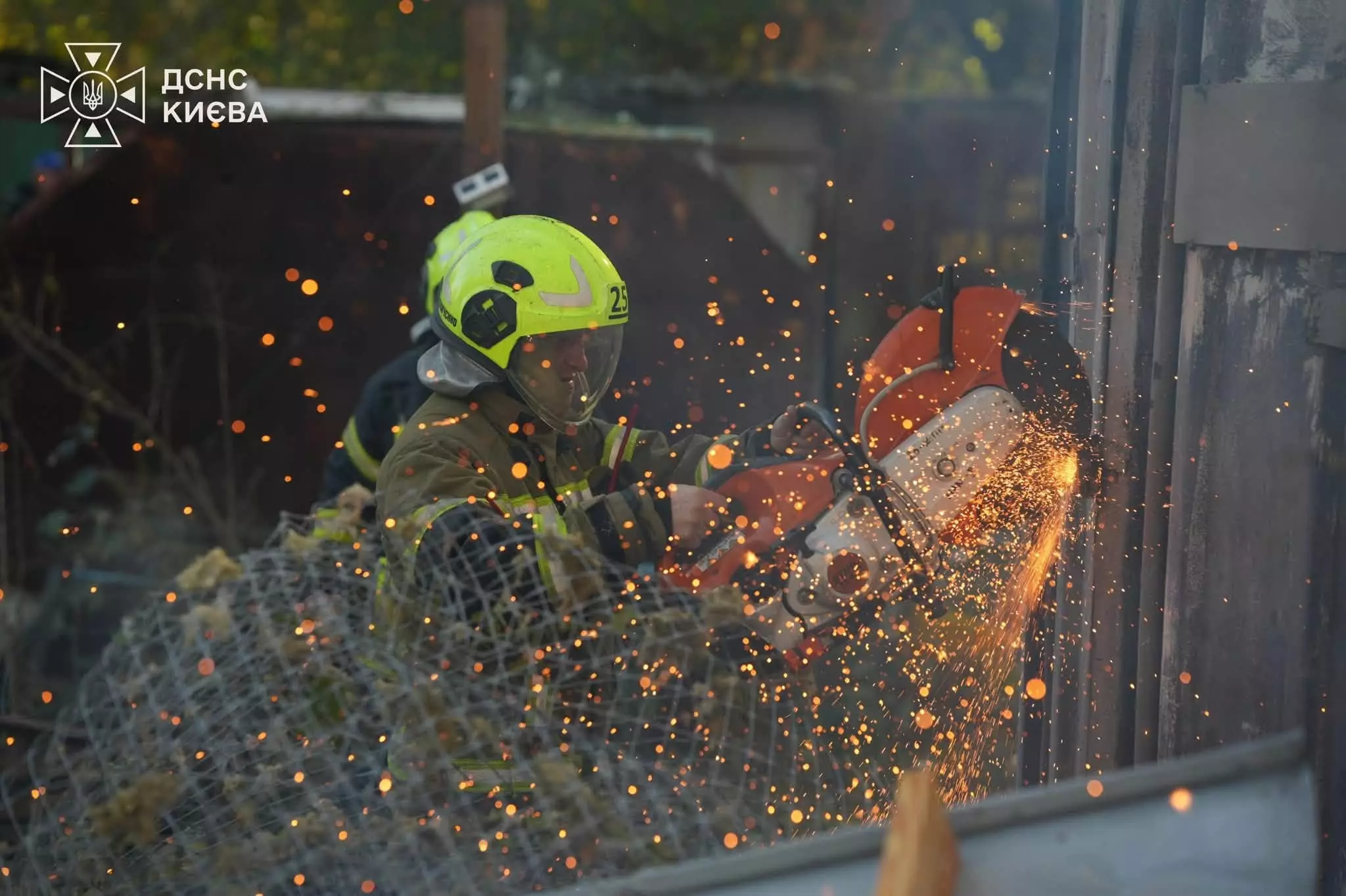 Рятувальник розрізує металеву конструкцію болгаркою, іскри летять в різні боки