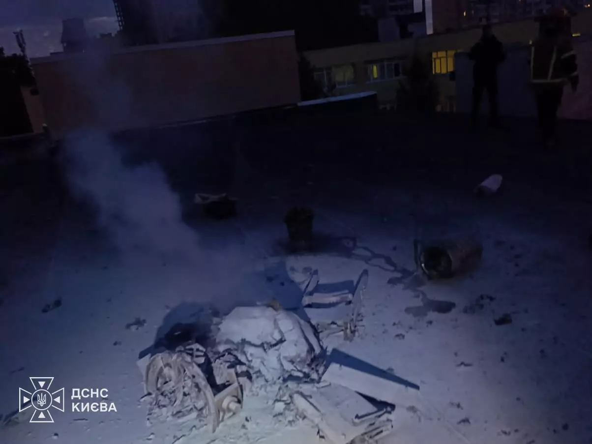 Вид з висоти на пошкоджений дах будівлі з дымом після ворожої атаки у столиці