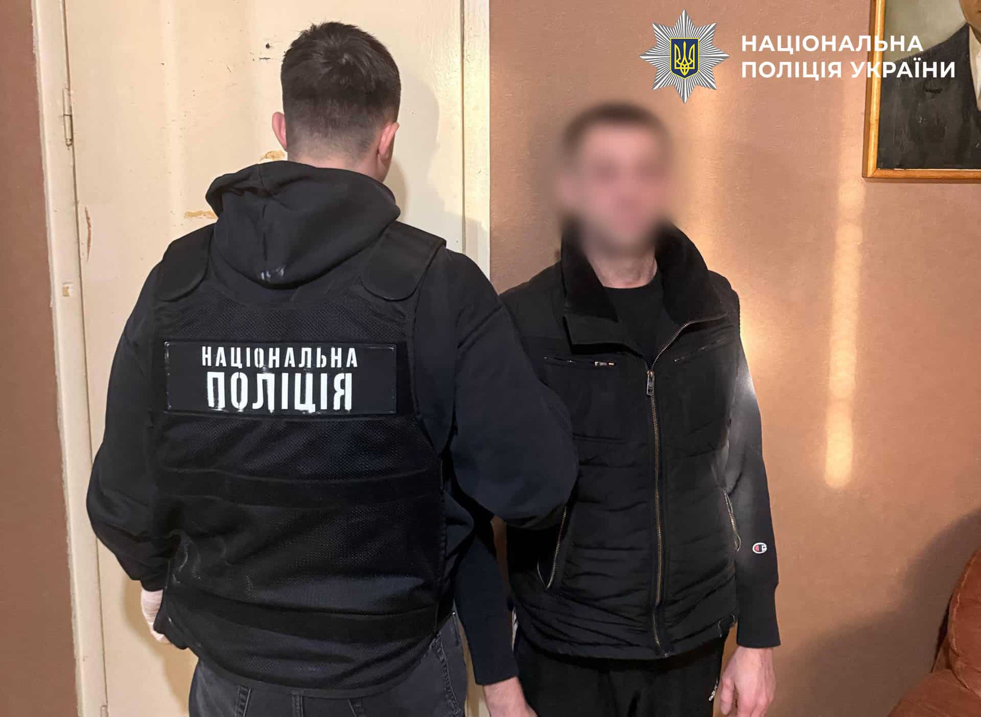 Поліцейський з затриманим чоловіком у приміщенні під час оформлення підозри за незаконний збут наркотиків