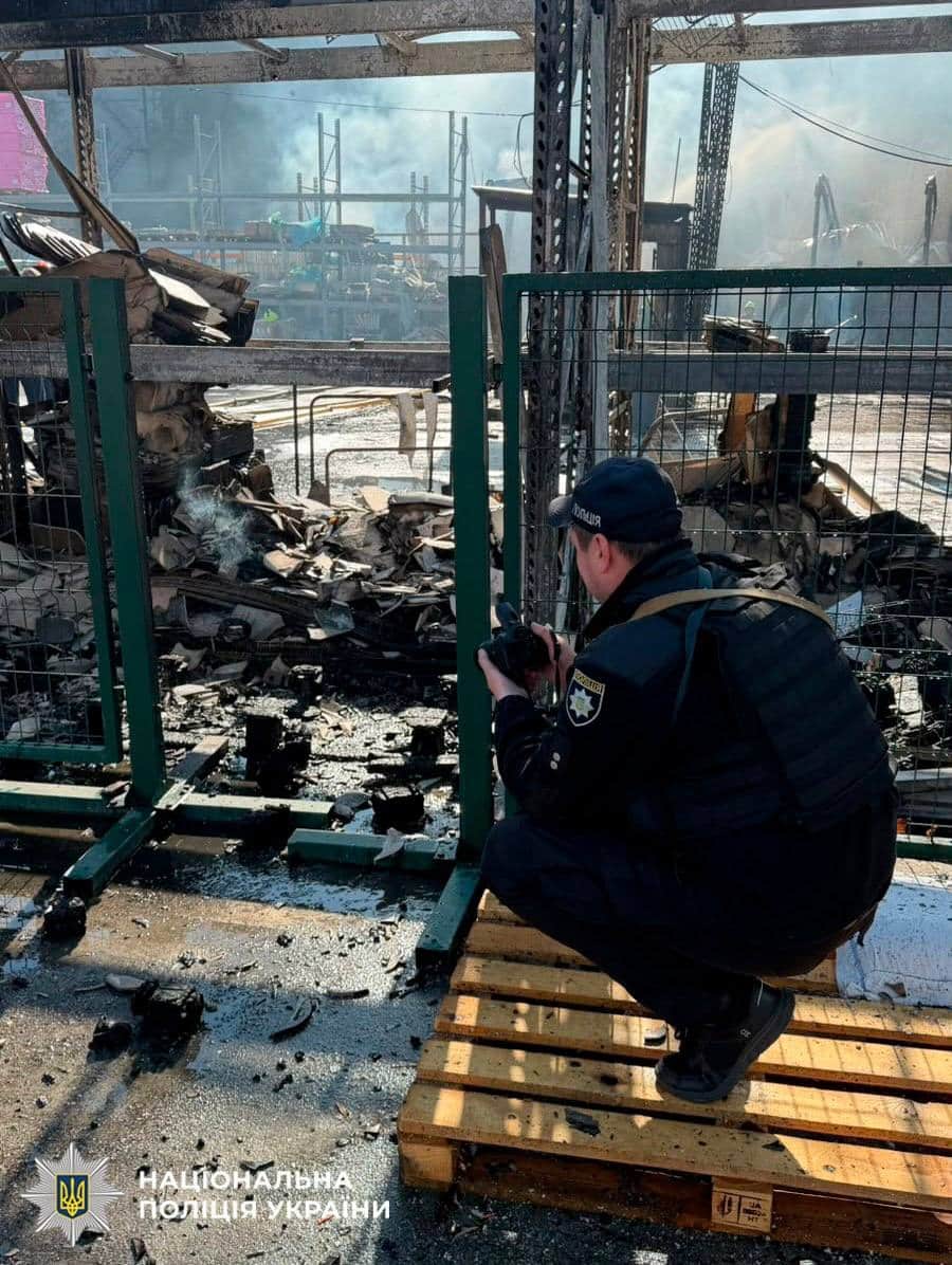 Поліцейський оглядає обгоріли залишки будівельних конструкцій і металу на місці удару
