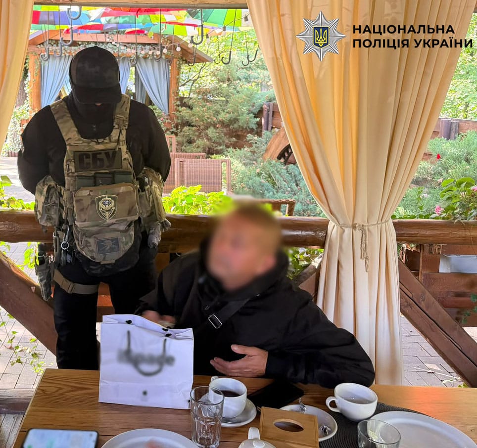 Оперативник СБУ та затриманий чоловік під час допиту в ресторані під час проведення операції