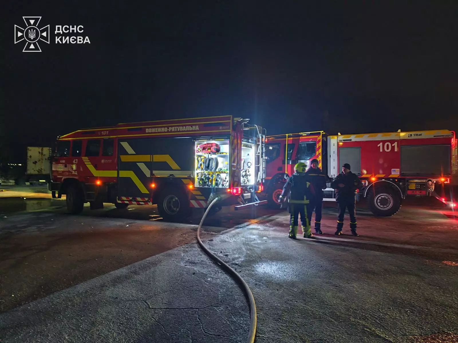Пожежні автомобілі ДСНС і рятувальники на місці пожежі на парковці