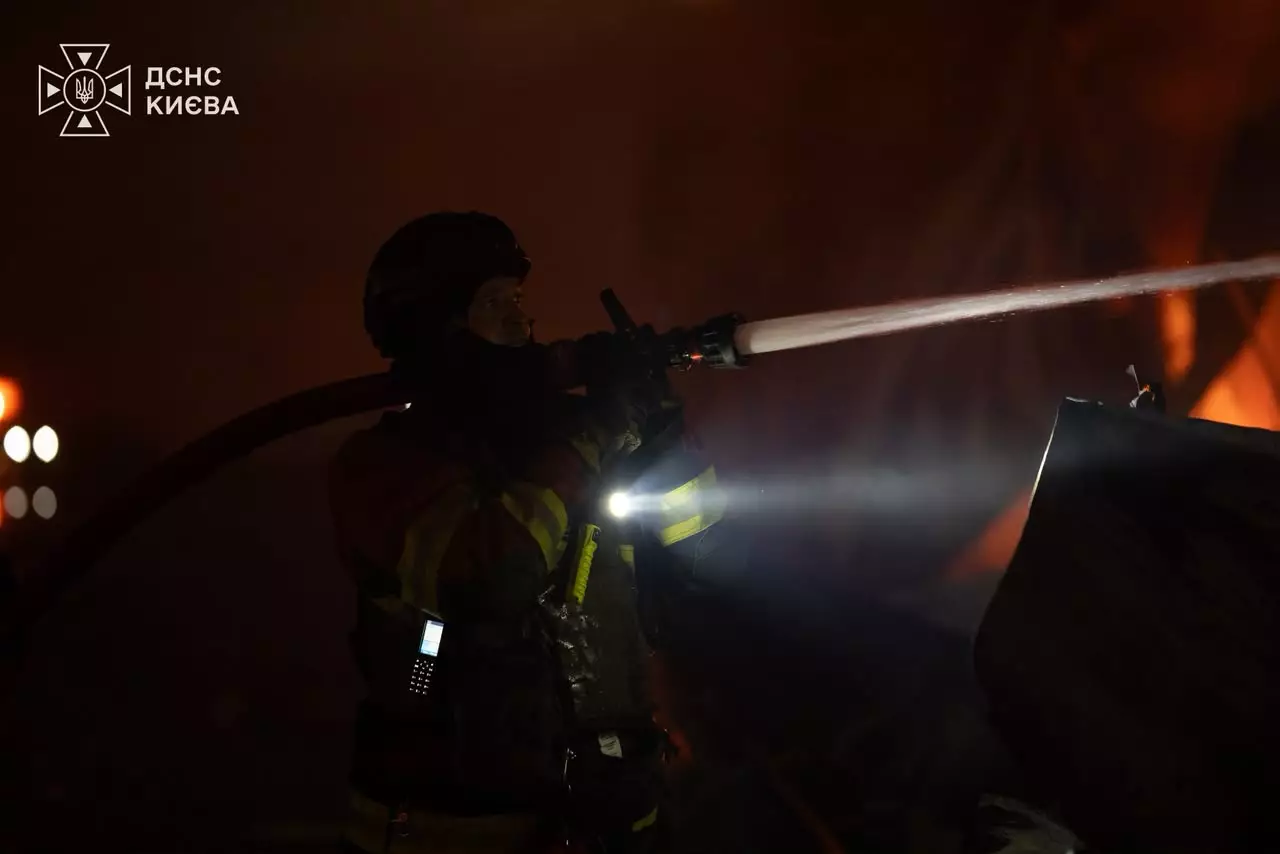Рятувальник гасить пожежу після обстрілу Києва