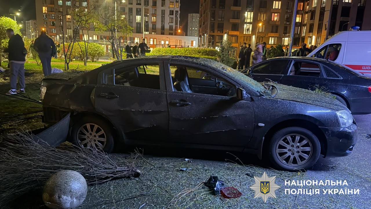 Автомобіль зі слідами пошкодження від вибуху серед уламків на території житлового дворика