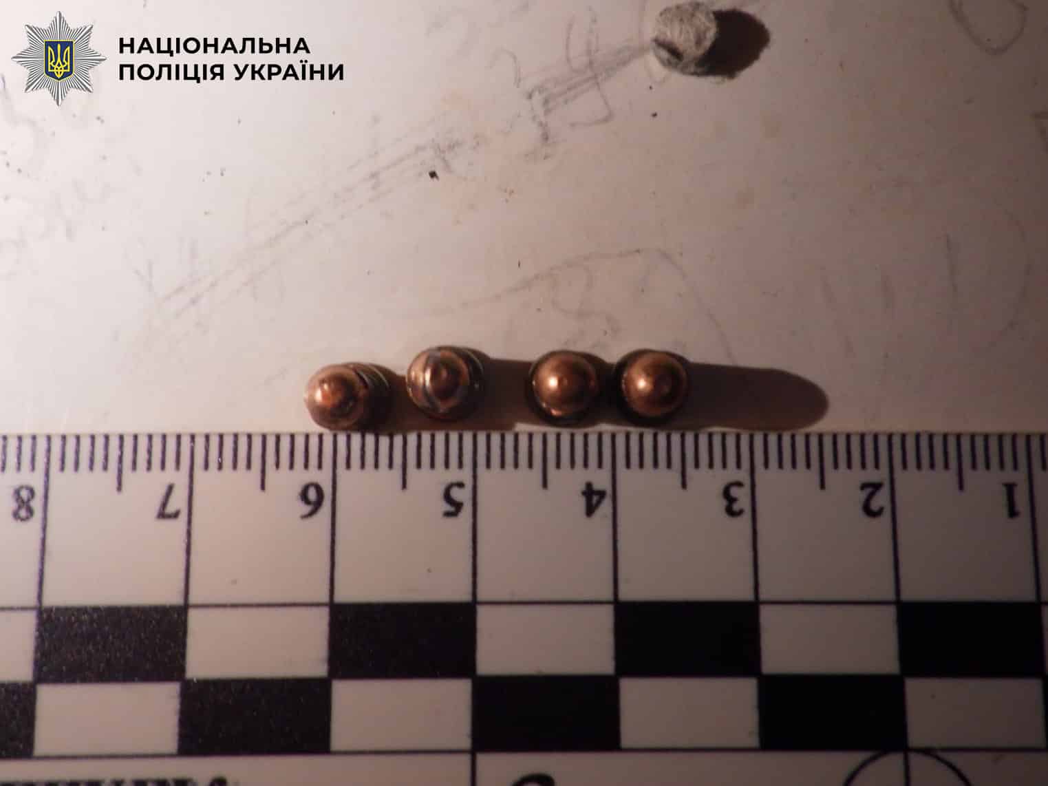 Чотири куль від стартового пістолета розташовані на вимірювальній лінійці поліції України
