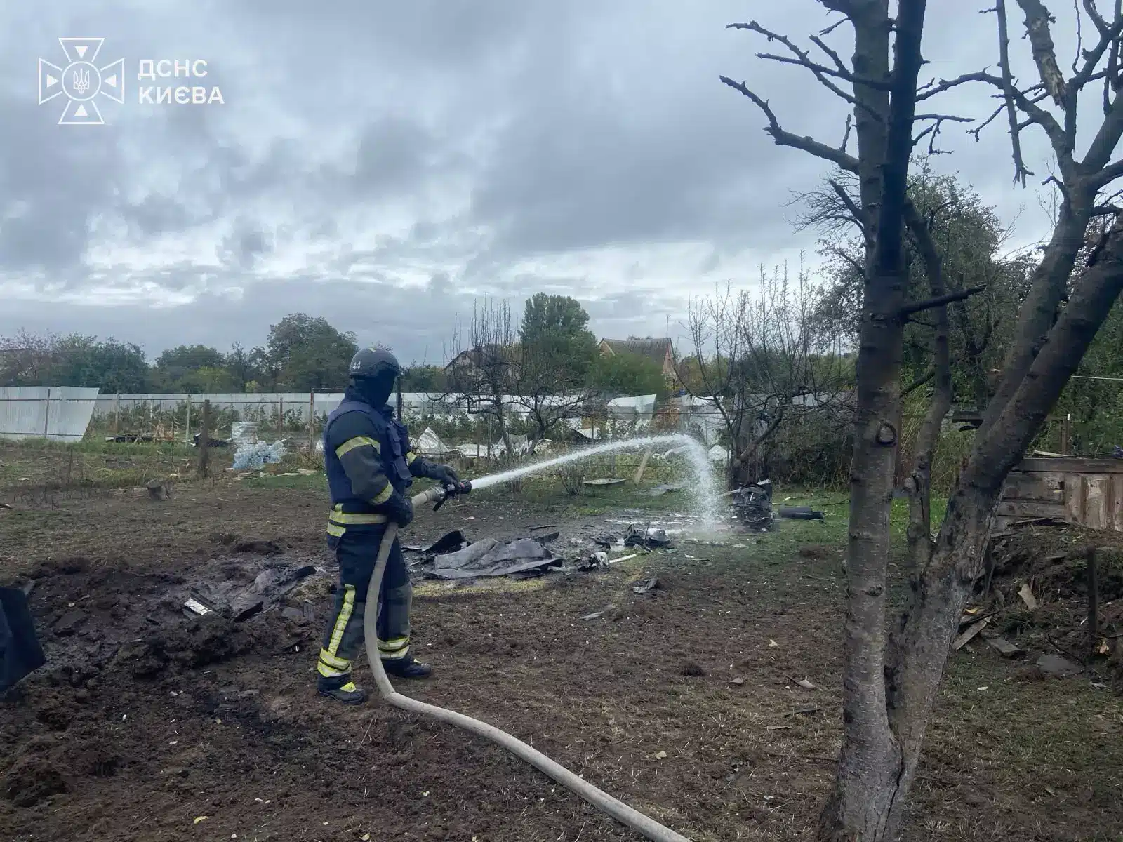 Рятувальник гасить залишки пожежі на території приватного будинку у Солом'янському районі