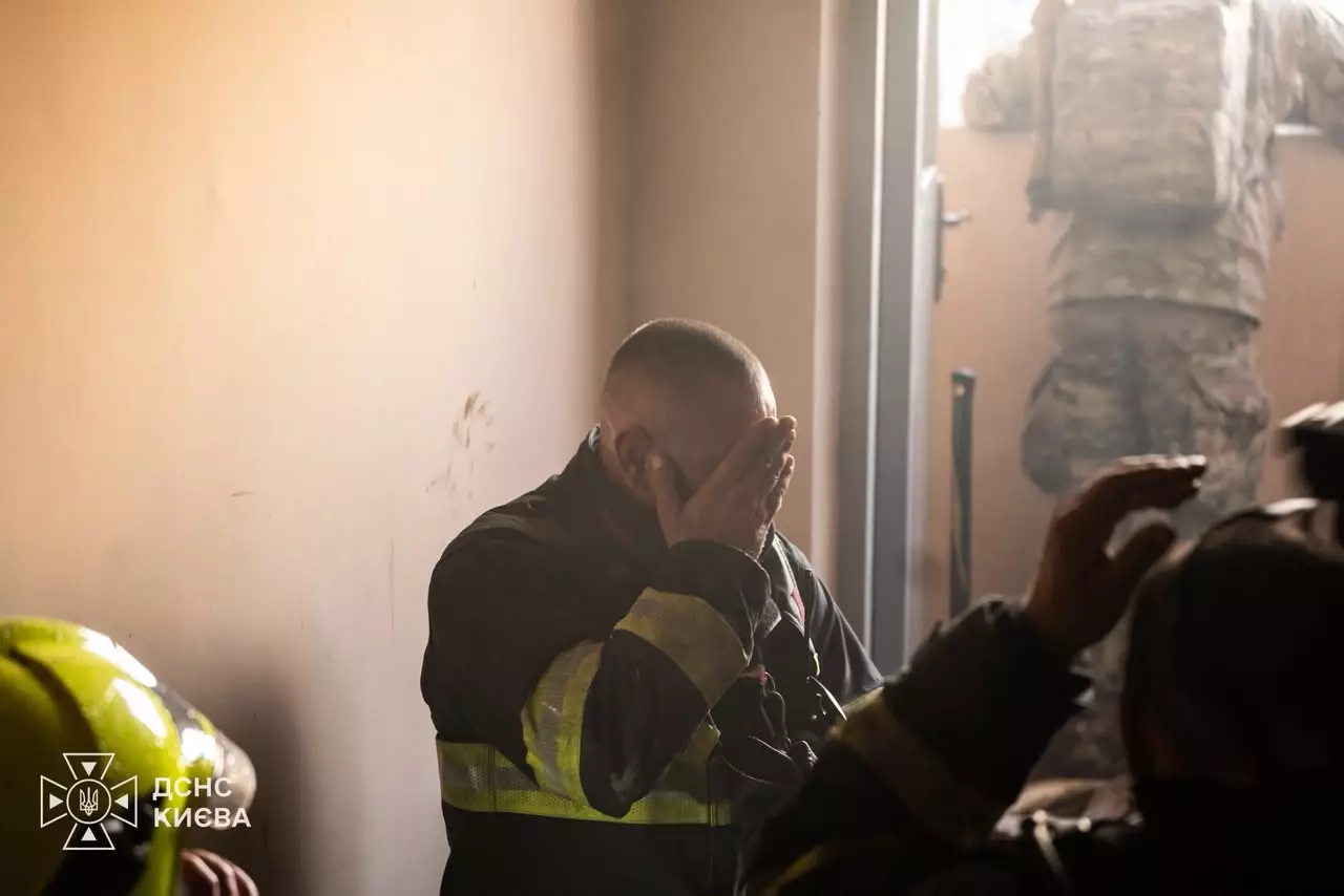 Рятувальник у жилеті з написом біля будинку під час пошуку людей під завалами