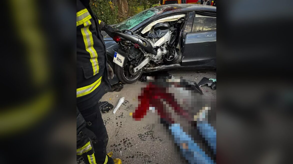 Рятувальник біля легковика, в який врізався мотоцикл, на асфальті лежить людина